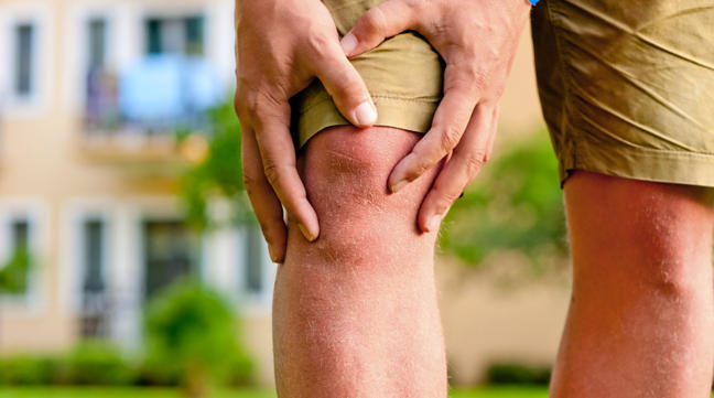 man holding knee because of arthritis pain
